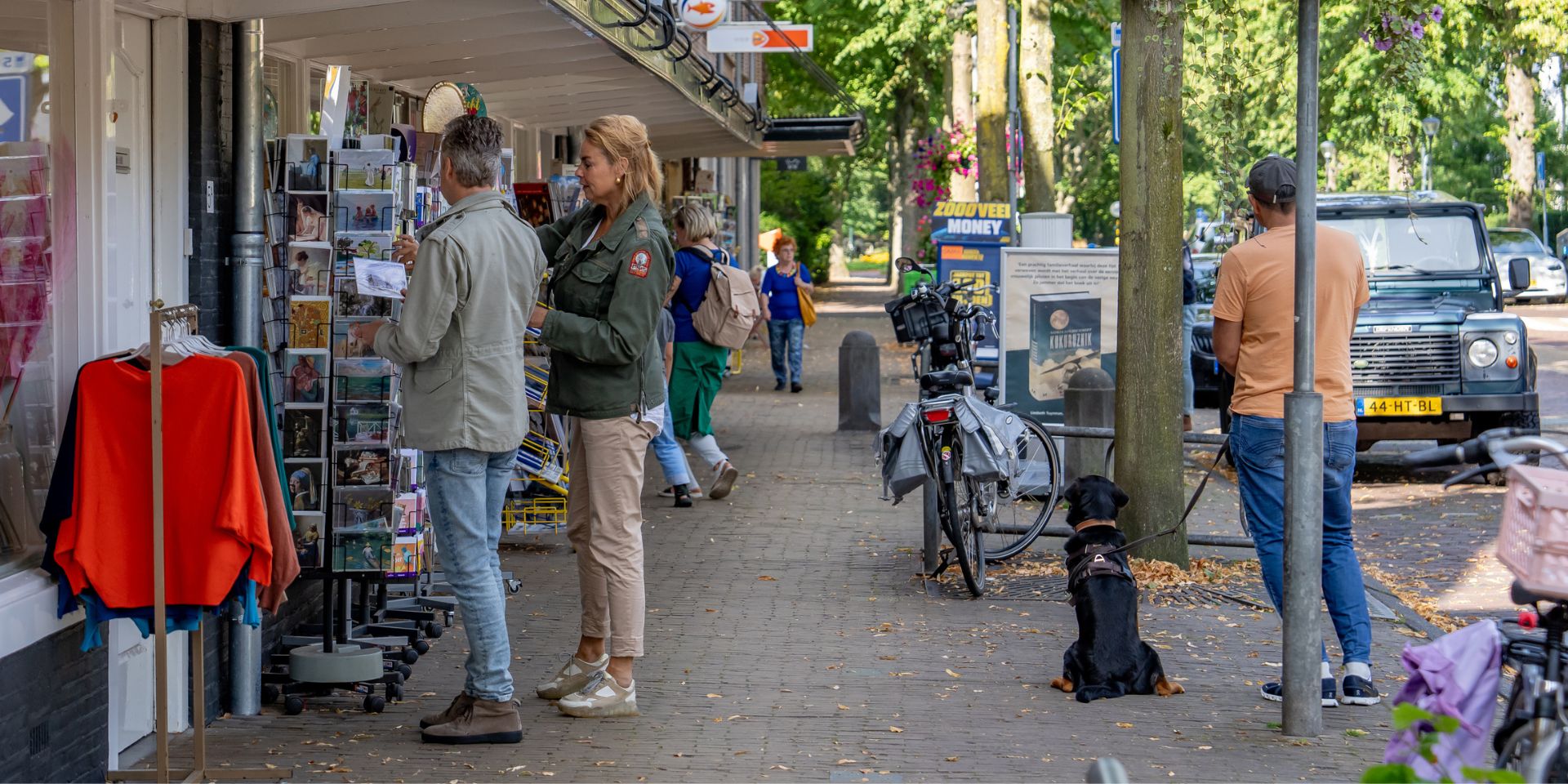 Winkelstraat in België, mensen kijken naar ansichtkaarten